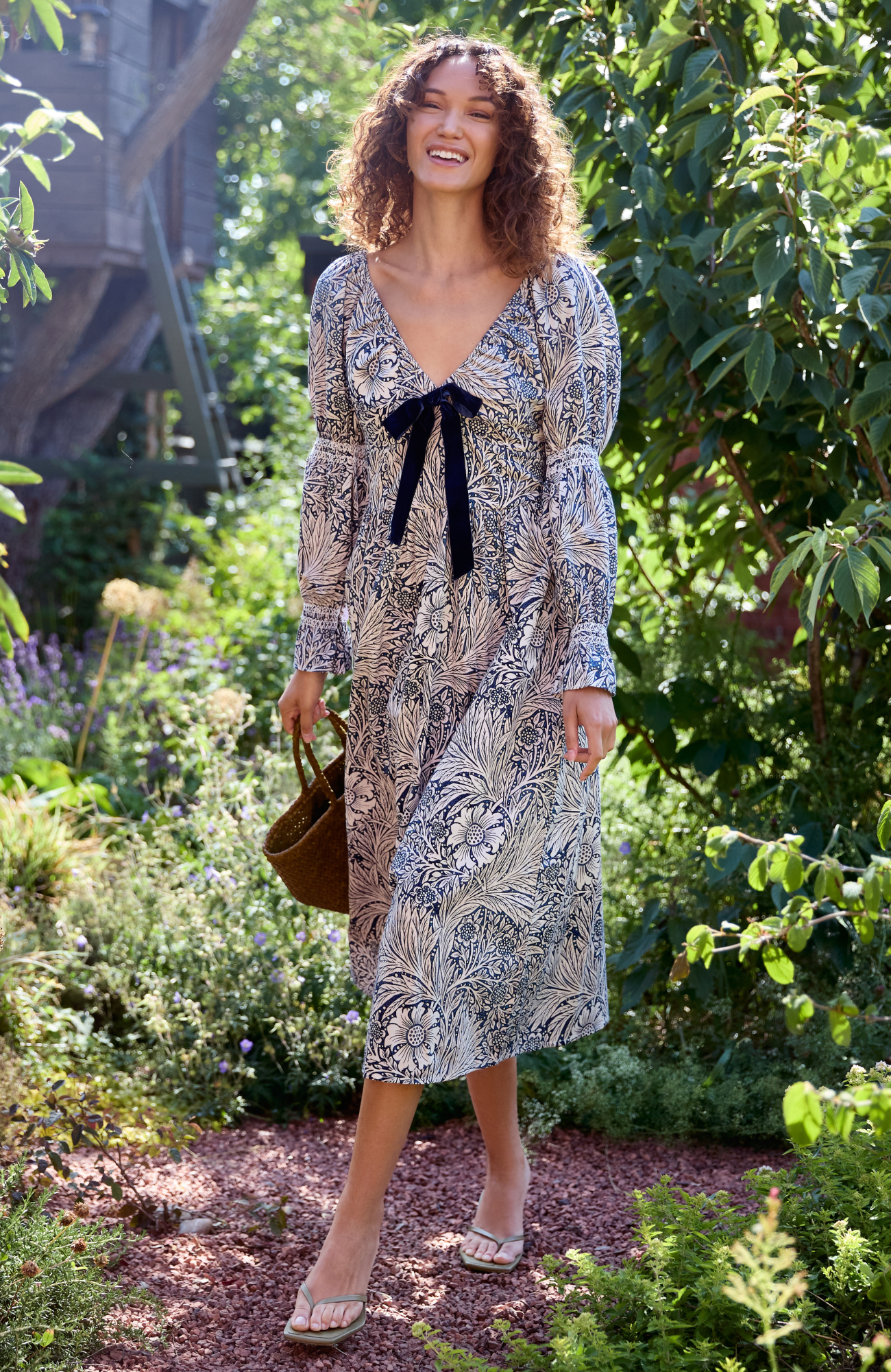 Woman in a patterned dress standing in a garden